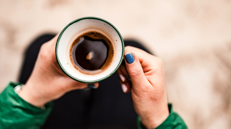 hands holding cup of espresso