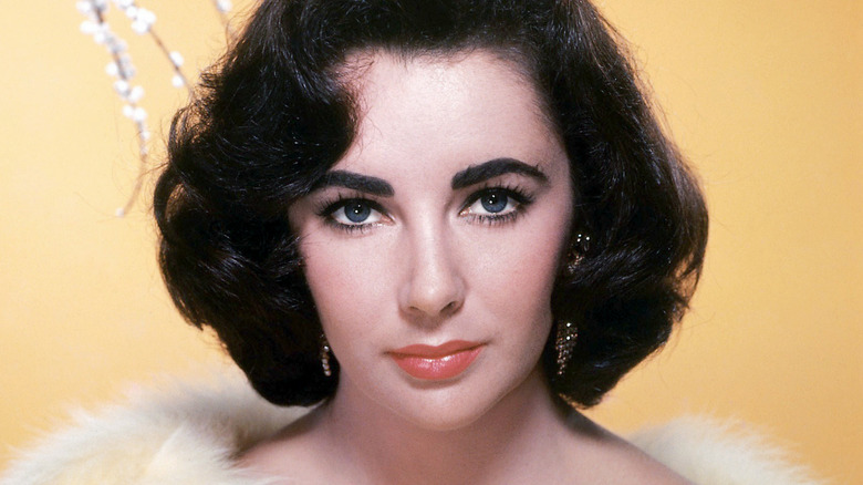 Elizabeth Taylor wearing fur and earrings.