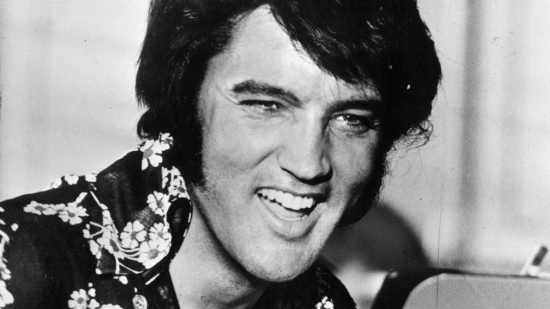 Elvis Presley smiling in a Hawaiian shirt
