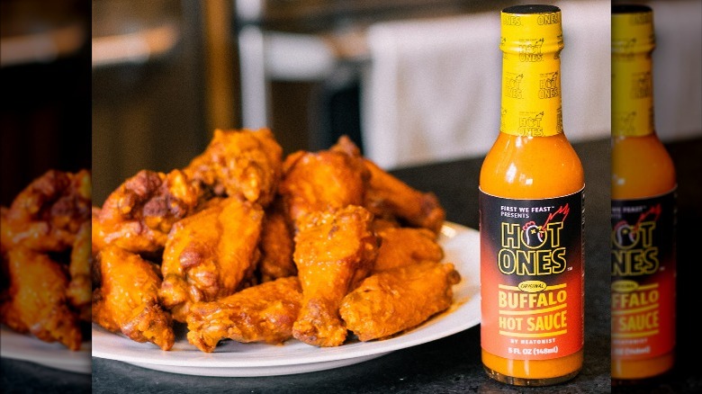 Buffalo hot sauce beside wings