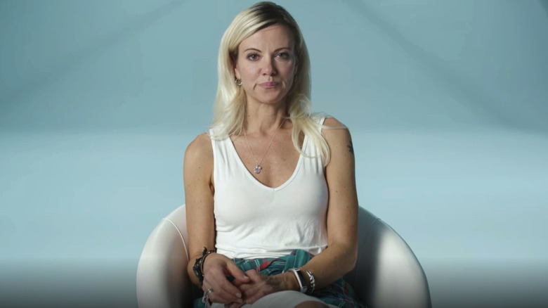 Sarma Melngailis sitting in white chair with serious expression