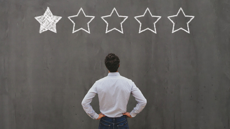 man standing in front of chalk outline for one star review