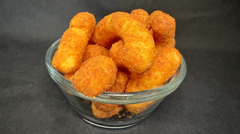 A glass bowl of Cheeto puffs