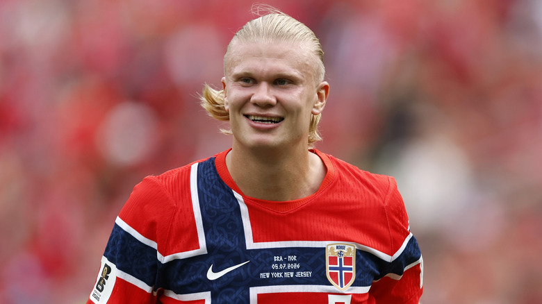 Norwegian soccer player Erling Haaland smiling on the field.