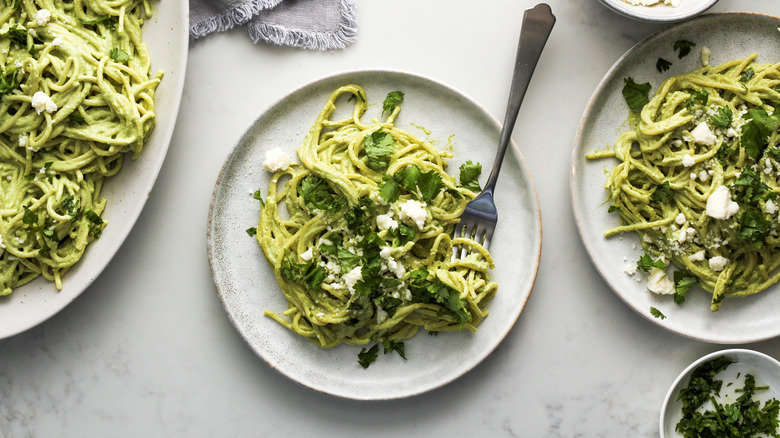 spaghetti with green sauce on ceramic plate