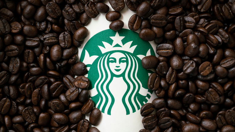 Starbucks logo peeking out beneath coffee beans