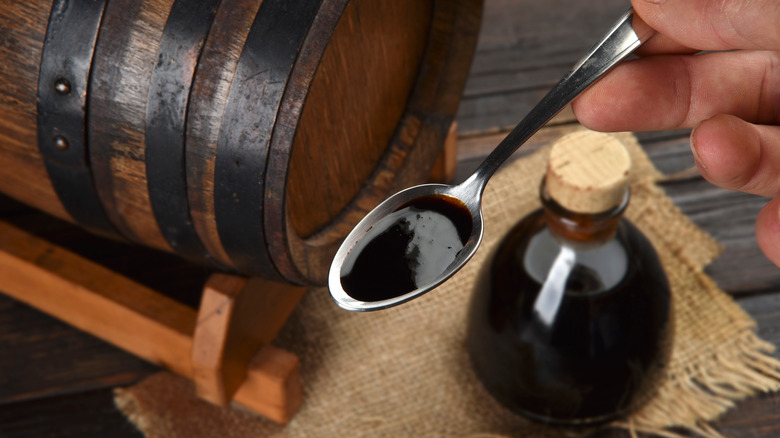 Man holding spoonful of balsamic vinegar 