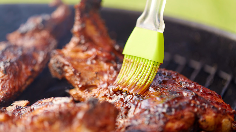 Basting chicken on the grill with a basting brush