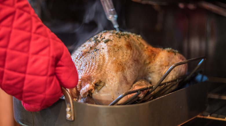 Turkey getting basted out of the oven