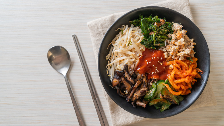 Black bowl full of bibimbap ingredients