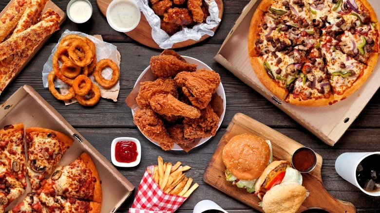 table of fast food pizza, chicken, burgers