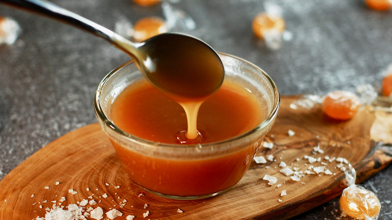 Spoon dipped into bowl of caramel