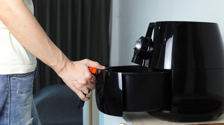 An air fryer drawer being pulled out