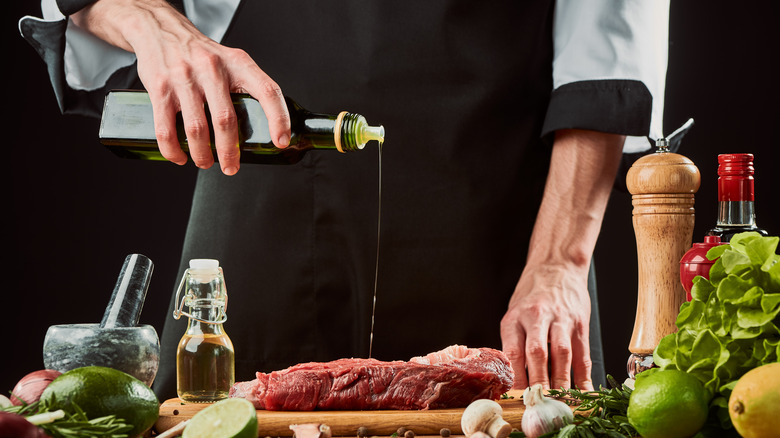 Oil being drizzled onto raw steak