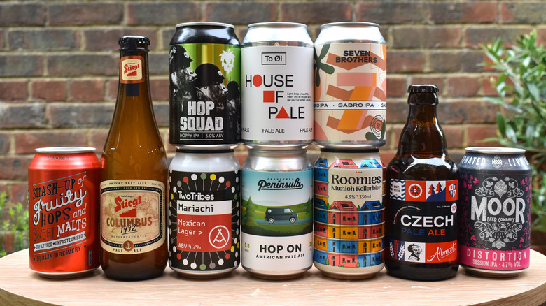 A collection of various pale ales in bottles and cans on a tabletop