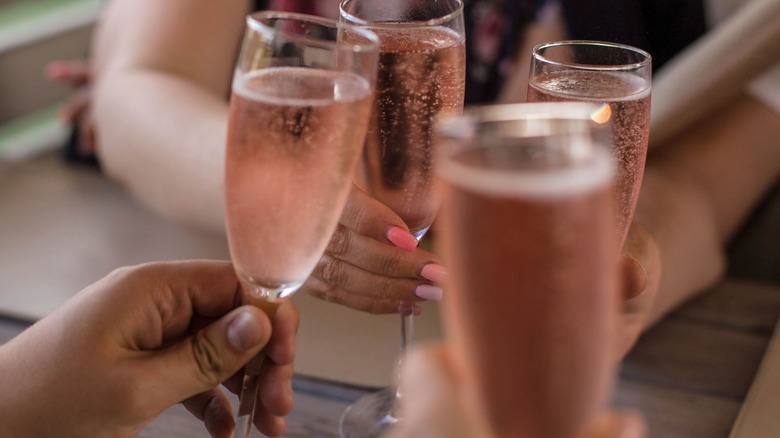 People doing a cheers with glasses of Prosecco rosé