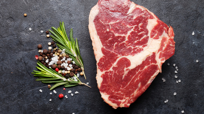 Raw beef steak on black background