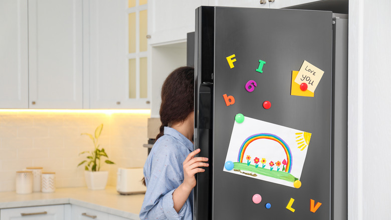 someone looking in a refrigerator 