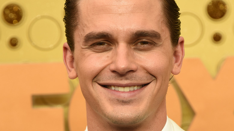 Antoni Porowski smiles with hair slicked back in white shirt