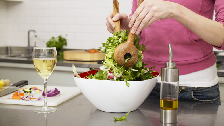 Person mixing salad