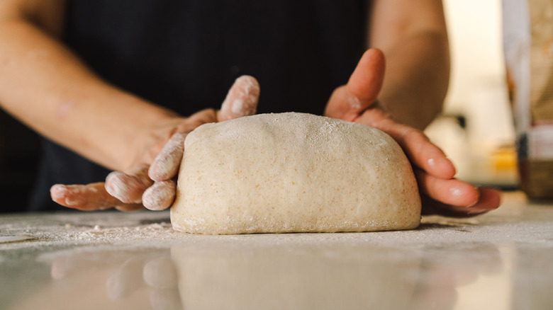 Hands shaping sourdough bread dough