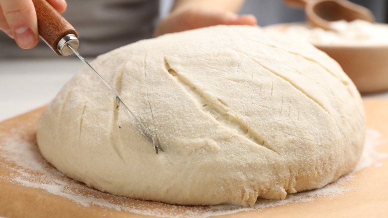 Hand scoring sourdough bread dough