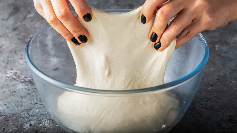 Hands performing stretch-and-fold on sourdough