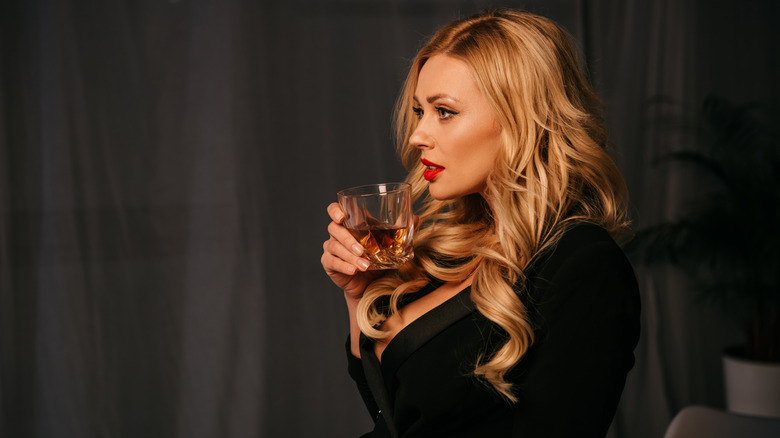 Woman holding a glass of whiskey