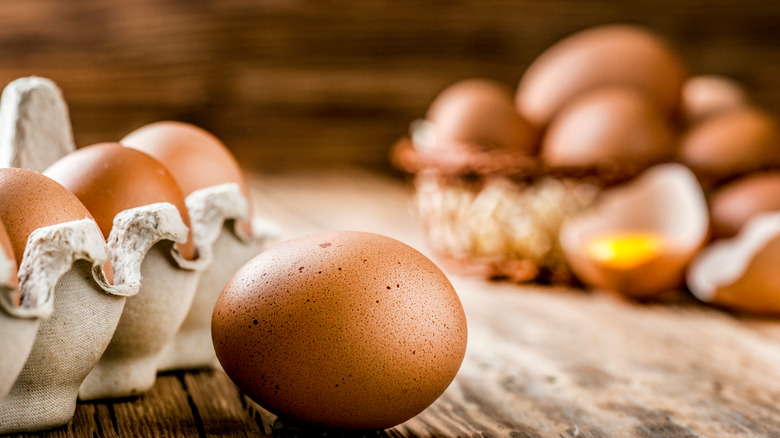 Carton and bowl of brown eggs