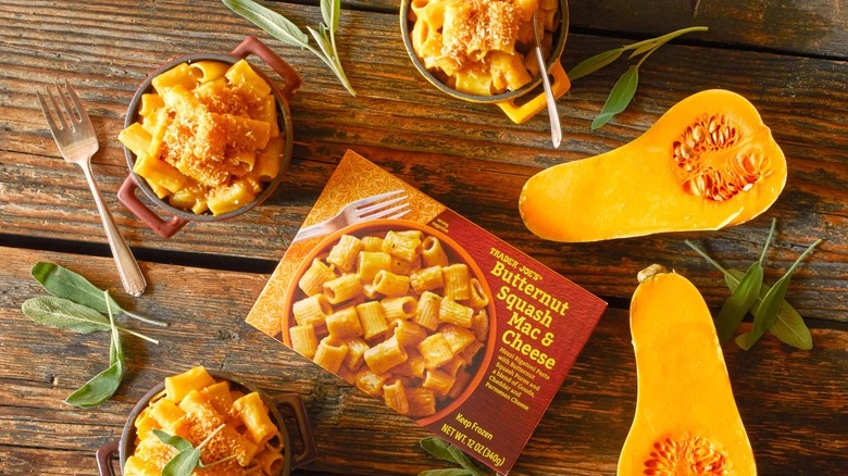 Butternut mac and cheese surrounded by sage leaves, squash, and bowls of the mac and cheese