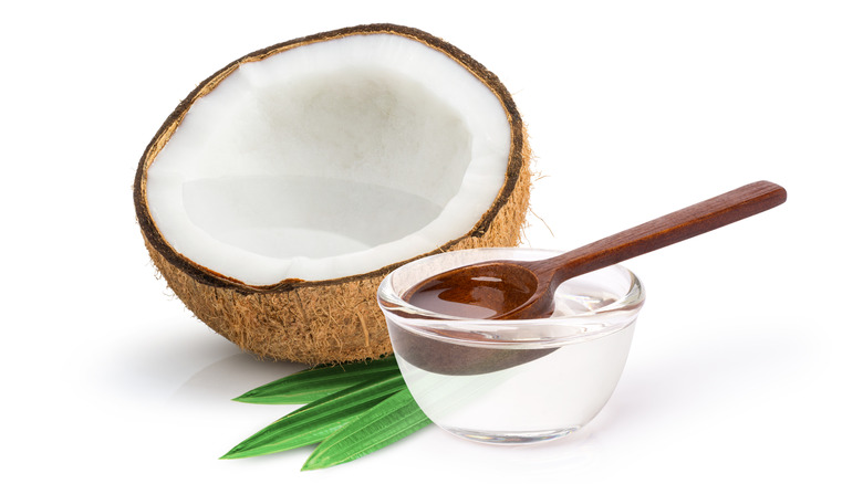 half a coconut and bowl of coconut oil