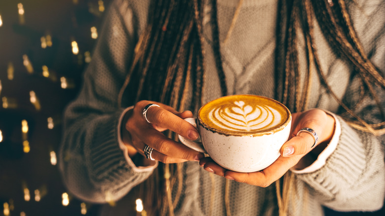 hands holding pumpkin spice latte