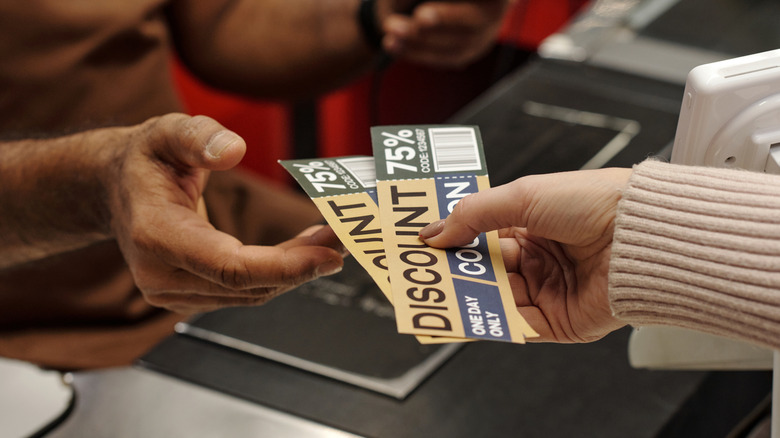 Customer handing cashier coupons