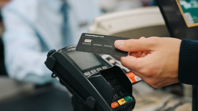 hand with card at register scanner