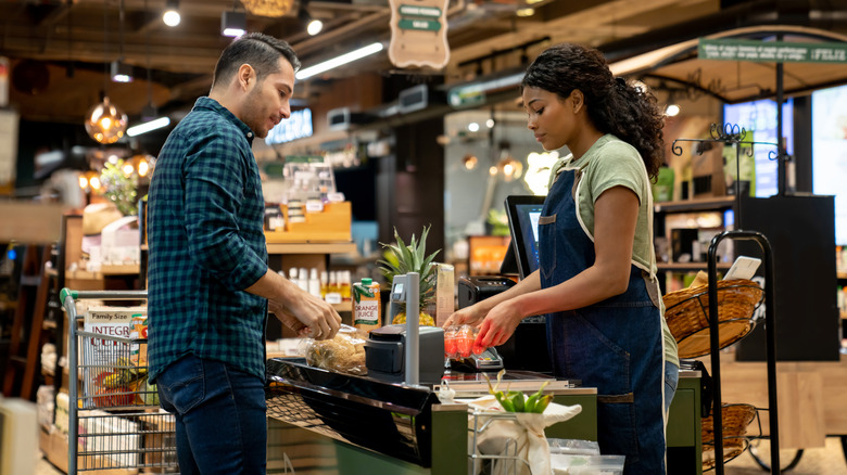 Cashier ringing up groceries for customer