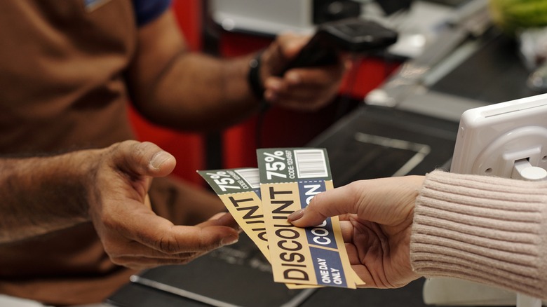 shopper handing over coupons at checkout