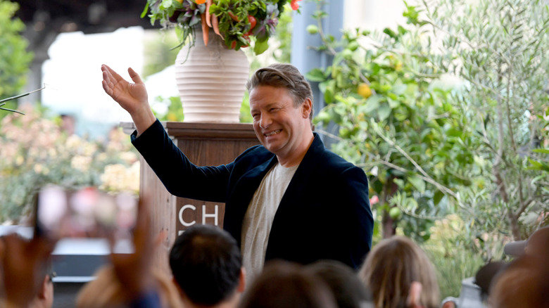 Jamie Oliver smiling at an audience at an event in 2025