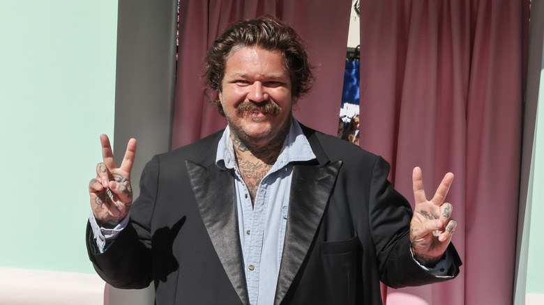 Matty Matheson smiling and giving hand peace signs