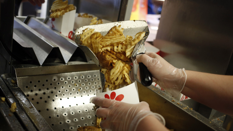 Chick-fil-A employee pouring fries into container