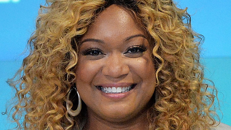 Sunny Anderson smiling with curly hair