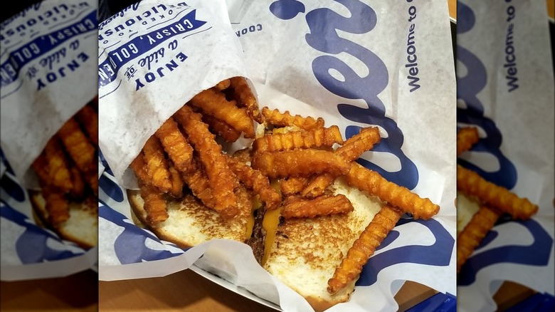 Bag of sweet potato fries on top of a toasted bun at Culver's restaurant.