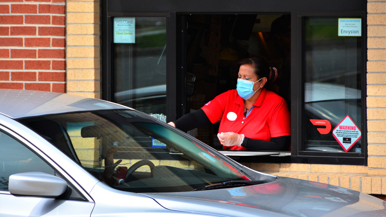 Chick-fil-A employee serving customer at drive-through