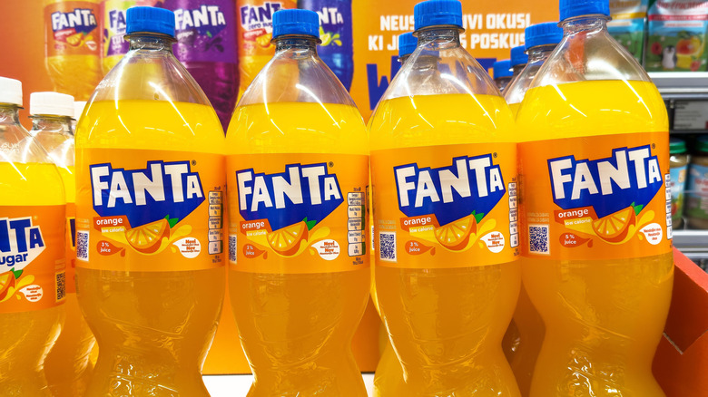 Bottles of orange Fanta on grocery store shelf