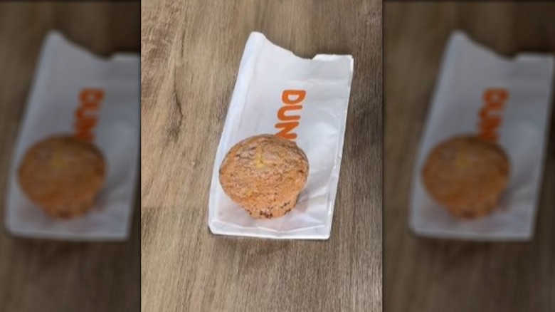 Coffee cake muffin sitting on Dunkin bag