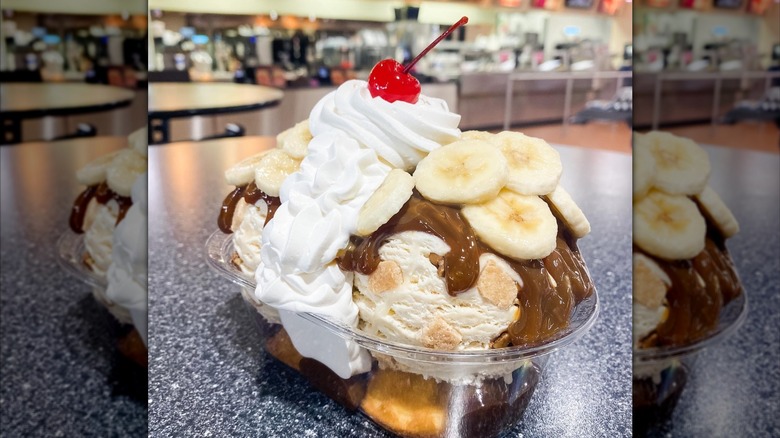 Ice cream sundae with banana slices, whipped cream and maraschino cherry on top