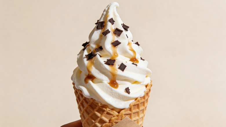 waffle cone filled with vanilla swirled ice cream and chocolate chip topping and caramel drizzle