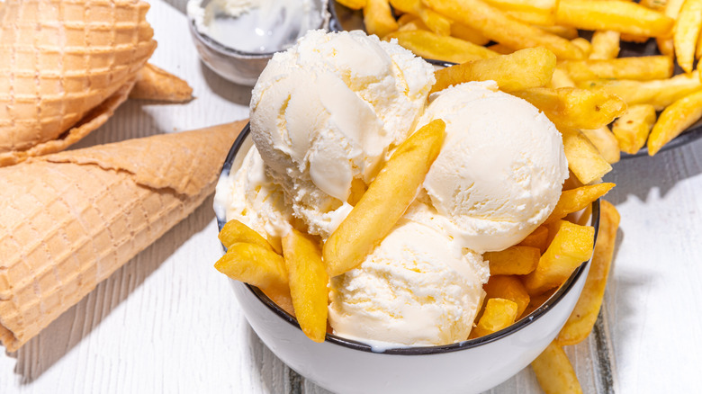 scoops of vanilla ice cream with French fries surrounding and in the bowl