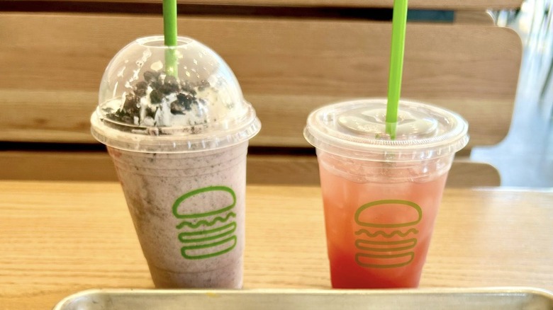 milkshake with whipped cream and chocolate topping and drink in takeout cups from Shake Shack