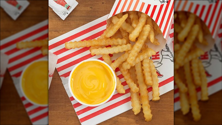 Portillo's crinkle fries with cheese sauce in a plastic cup on the side