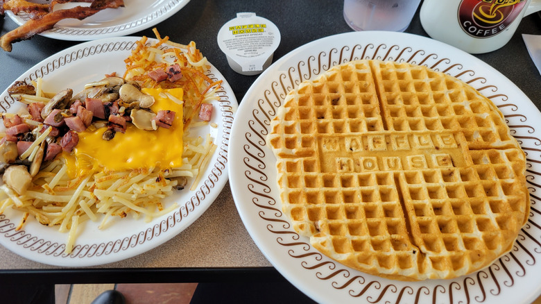 Waffle House waffle with logo imprinted into waffle, next to hash browns with toppings.